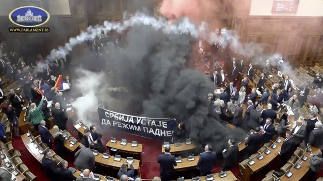 Anggota parlemen oposisi Serbia melepaskan granat asap di dalam parlemen Serbia, di Beograd, Serbia, Selasa (4/3/2025). Foto: SERBIAN PARLIAMENT POOL / VIDEOPLUS via REUTERS