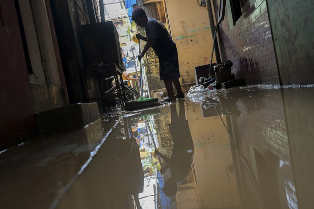 Warga membersihkan lumpur di depan rumahnya pascabanjir di Kampung Melayu, Jatinegara, Jakarta Timur, Rabu (5/3/2025). Foto: Fauzan/ANTARA FOTO