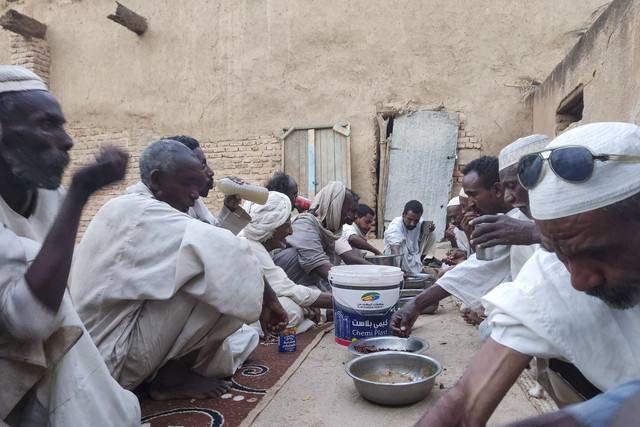 Para pria berkumpul untuk berbuka puasa di makam dan masjid al-Sayyid al-Hasan di kota Kassala, Sudan, pada hari pertama bulan suci Ramadan (1/3/2025). Foto: AFP