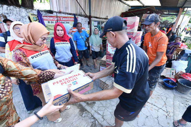 Relawan Pertamina menyerahkan bantuan untuk korban banjir di Kampung Lengkak, Kelurahan Bekasi Jaya, Kota Bekasi. Foto: Dok. Pertamina