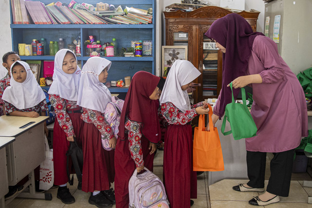 Guru membagikan paket takjil kepada siswa dalam pelaksanaan Program Makan Bergizi Gratis (MBG) di SD Negeri 25 Palembang, Sumatera Selatan, Kamis (6/3/2025). Foto: Nova Wahyudi/ANTARA FOTO