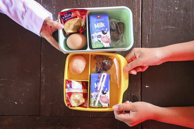 Seorang siswa menunjukkan menu makan bergizi gratis bulan Ramadhan di SDN Slipi 15, Jakarta, Kamis (6/3/2025). Foto: Sulthony Hasanuddin/ANTARA FOTO 