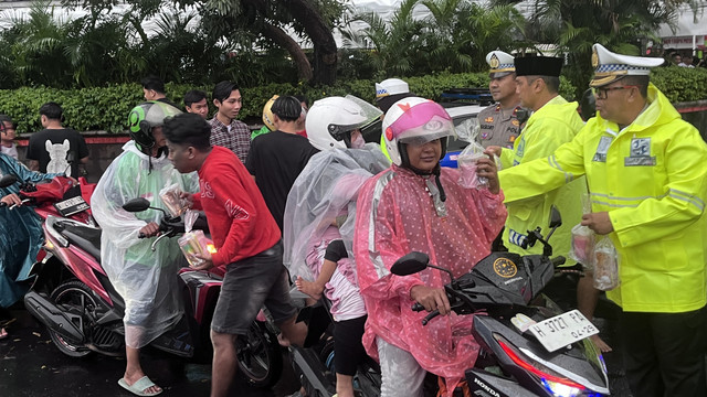 Kapolrestabes Semarang Kombes Pol M Syahduddi dan anggotanya saat membagikan takjil kepada pengendara di Simpang Lima Semarang. Foto: Intan Alliva/kumparan