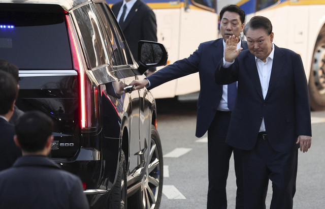 Presiden Korea Selatan Yoon Suk-yeol melambaikan tangan saat pembebasan dirinya setelah Pengadilan Korea Selatan menyatakan bebas di Uiwang, Korea Selatan, Kamis (8/2/2025).  Foto: Kim Hong-Ji/Reuters