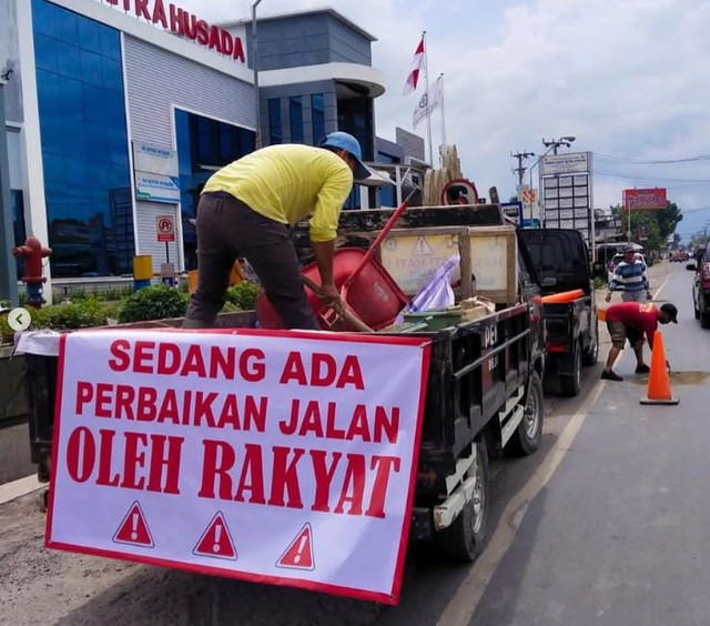 Proses perbaikan jalan berlubang di Pringsewu yang dilakukan oleh masyarakat | Foto : Ist