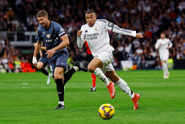 Pemain Real Madrid Kylian Mbappe berebut bola dengan pemain Rayo Vallecano Florian Lejeune pada pertandingan Liga Spanyol di Santiago Bernabeu, Madrid, Spanyol, Minggu (9/3/2025). Foto: Susana Vera/REUTERS