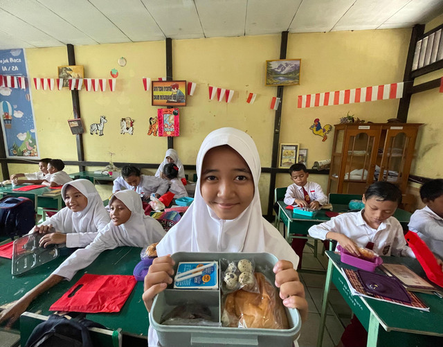 Siswa di Pontianak menunjukkan menu Makan Bergizi Gratis. Foto: Rabiansyah/Hi!Pontianak