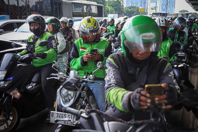 Pengemudi ojek online (ojol) menunggu datangnya penumpang di Halte LRT Pancoran, Jakarta, Rabu (12/3/2025). Foto: Iqbal Firdaus/kumparan