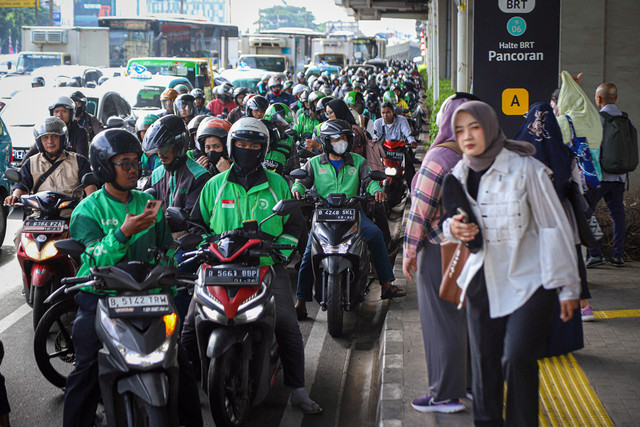 Pengemudi ojek online (ojol) menunggu datangnya penumpang di Halte LRT Pancoran, Jakarta, Rabu (12/3/2025). Foto: Iqbal Firdaus/kumparan