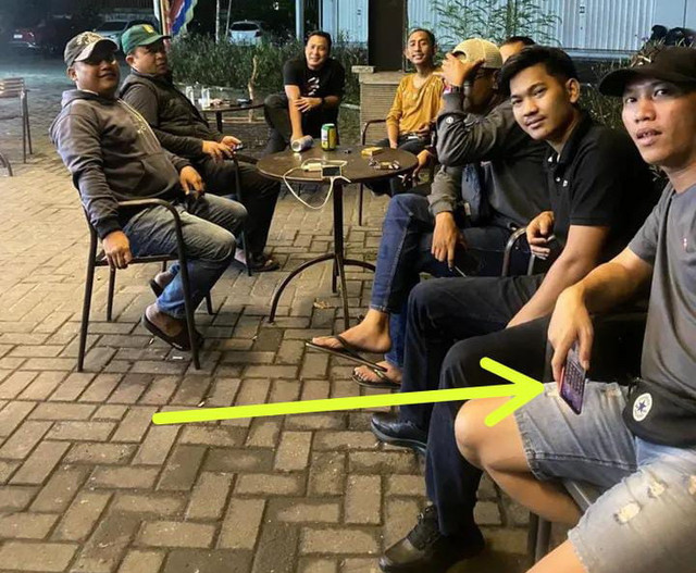 Foto seorang pria memegang ponsel diduga sedang main judi online diunggah di Polsek Pasar Kemis. Foto: Dok. Istimewa