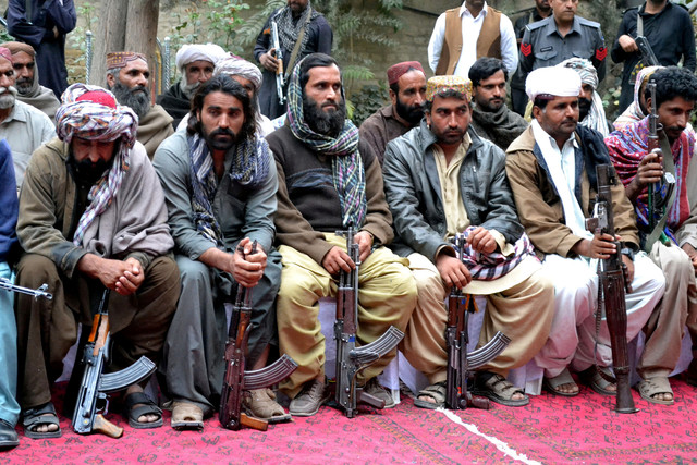 Militan dari organisasi pemberontak Baloch Liberation Army dan United Baloch Army, menyerahkan senjata mereka kepada Kepala Suku Marri dan menteri provinsi Pakistan Nawab Changaiz Marri saat upacara penyerahan diri di Quetta, pada 29 Oktober 2015. Foto: Banaras KHAN / AFP