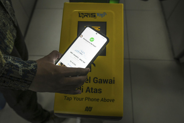 Calon penumpang menempelkan ponsel ke mesin pemindai untuk membayar kereta Moda Raya Terpadu (MRT) di Stasiun MRT Bundaran HI, Jakarta, Jumat (14/3/2025).  Foto: Sulthony Hasanuddin/ANTARA FOTO 