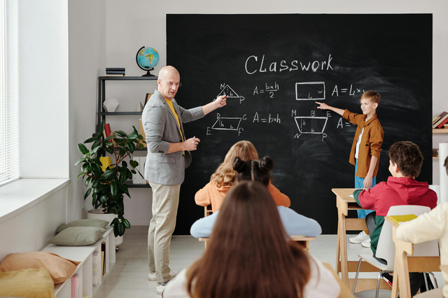 Gambar : Seorang Guru Sedang Mengajar di kelas Sumber: pexels.com