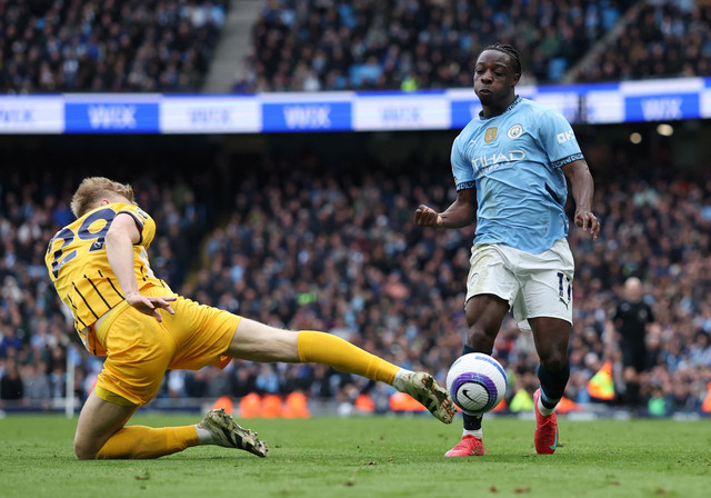 Jan Paul van Heck tekel Jeremy Doku saat Man City vs Brighton and Hove Albion dalam laga pekan ke-29 Liga Inggris 2024/25 di Stadion Etihad, Sabtu (15/3) malam WIB. Foto: REUTERS/Phil Noble