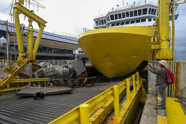 Jurnalis mengambil gambar kondisi jembatan bergerak usai ditabrak KMP Portlink III saat akan bersandar di Dermaga Eksekutif Pelabuhan Merak, Kota Cilegon, Banten, Senin (17/3/2025). Foto: Angga Budhiyanto/ANTARA FOTO 