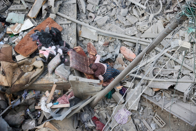 Warga Palestina mencari barang-barang yang bisa diselamatkan di antara puing-puing rumahnya yang hancur akibat serangan Israel di kamp pengungsi Nuseirat, Jalur Gaza bagian tengah, Selasa (18/3/2025). Foto: Eyad BABA / AFP