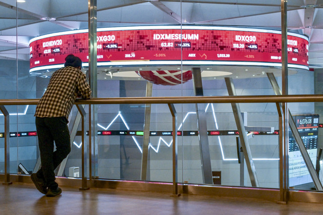 Warga memantau pergerakan saham di Bursa Efek Indonesia, Jakarta, Selasa (18/3/2025). Foto: Bay Ismoyo/AFP