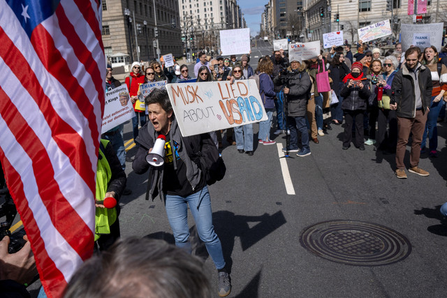 Orang-orang berunjuk rasa di 14th St NW untuk mendukung para pekerja USAID yang dipecat selama protes, Jumat, 28 Februari 2025, di kantor pusat USAID di Washington.  Foto: AP/Jacquelyn Martin