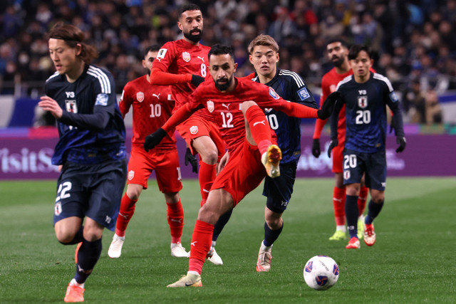 Pemain Timnas Jepang Ritsu Doan berebut bola dengan pemain Timnas Bahrain Mahdi Abduljabbar pada pertandingan Ronde 3 Kualifikasi Piala Dunia 2026 di Stadion Saitama, Saitama, Jepang, Kamis (20/3/2025). Foto: Kim Kyung-Hoon/REUTERS