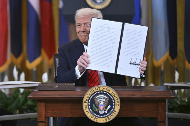 Presiden AS Donald Trump menunjukkan hasil tanda tangan perintah eksekutif di Gedung Putih, Washington DC, Amerika Serikat, Kamis (20/3/2025). Foto: Mandel Ngan/AFP