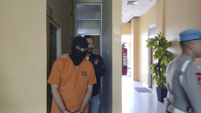 Polisi menggiring pelaku menaruh jasad Jefry Rarun yang termutilasi, Marcellino Rarun. Foto: Dok. kumparan