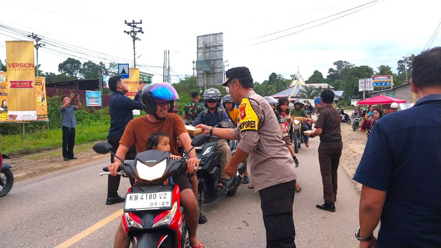 Wakapolres Sekadau membagikan takjil kepada pengendara. Foto: Dina Mariana/Hi!Pontianak