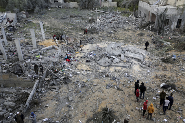 Warga Palestina memeriksa lokasi serangan Israel terhadap sebuah rumah, di Khan Younis di Jalur Gaza selatan, Kamis (20/3/2025). Foto: Hatem Khaled/REUTERS