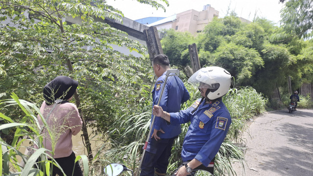 Petugas Damkar mencari hp wanita di Tangerang yang dibuang ke kali karena bertengkar dengan pacar. Foto: Dok. BPBD Kabupaten Tangerang