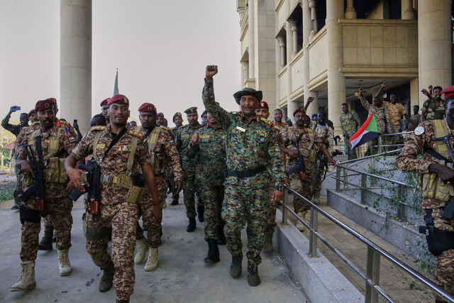 Kepala militer Sudan Jenderal Abdel-Fattah Burhan (tengah), disambut oleh pasukan saat tiba di Istana Republik, yang baru-baru ini direbut kembali dari kelompok paramiliter Pasukan Pendukung Cepat, di Khartoum, Sudan, Rabu (26/3/2025). Foto: AP Photo