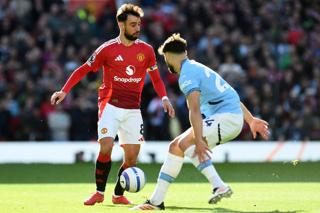Pemain Manchester United Bruno Fernandes berusaha melewati pemain Manchester City Josko Gvardiol pada pertandingan Liga Inggris di Old Trafford, Manchester, Inggris, Minggu (6/4/2025). Foto: Peter Powell/REUTERS