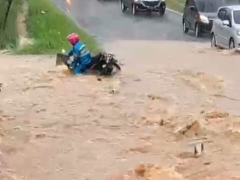 Pengendara sepeda motor hilang kendali saat melintasi arus banjir di Jalan Tirtayasa, perbatasan Kelurahan Campang Jaya dan Campang Raya, Kecamatan Sukabumi Bandar Lampung hingga erseret arus masuk ke dalam selokan | Foto : Ist