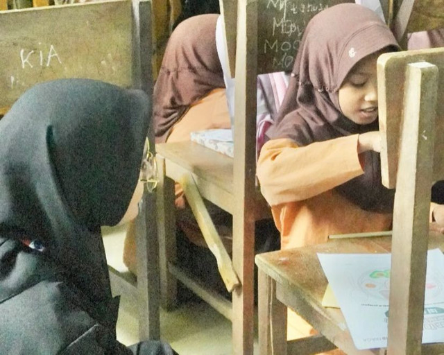 Membimbing Siswa Sekolah Dasar. Foto hanya ilustrasi, bukan yang sebenarnya. Sumber : Fida Rafalina