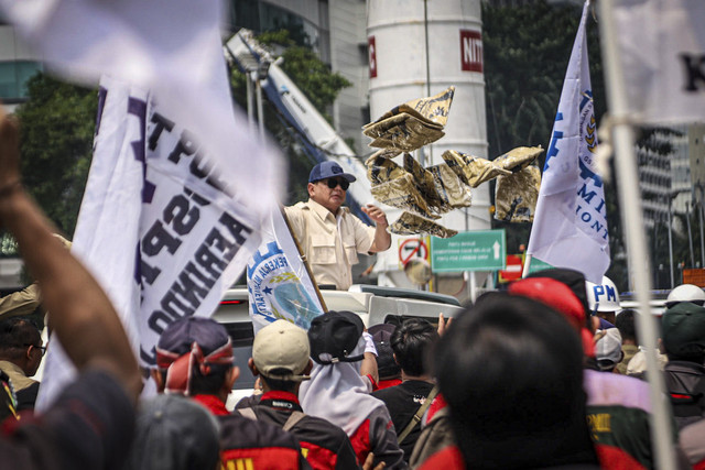 Presiden Republik Indonesia Prabowo Subianto membagikan kaos dari Mobil Maung saat meninggalkan perayaan May Day di kawasan Monas, Jakarta, Kamis (1/5/2025). Foto: Iqbal Firdaus/kumparan