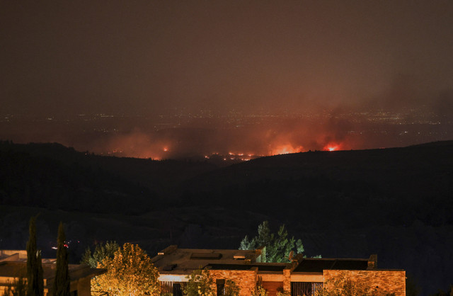 Api dan asap membumbung tinggi saat kebakaran hutan mengamuk akibat cuaca panas dan angin kencang di Neve Ilan, Israel, Rabu (30/4/2025). Foto: Ronen Zvulun/REUTERS