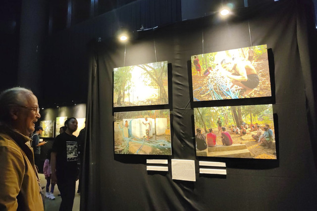 Pengunjung mengamati karya foto pada pameran foto 'Sing Penting Madhang' di Gallery Gelanggang Inovasi dan Kreativitas (GIK) Universitas Gadjah Mada (UGM), Kamis (1/5/2025) malam. Foto: Arfiansyah Panji Purnandaru/kumparan