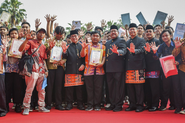 Gubernur DKI Jakarta Pramono Anung dan Wakil Gubernur DKI Jakarta Rano Karno berfoto bersama sejumlah warga penerima ijazah usai mengikuti upacara peringatan Hari Pendidikan Nasional 2025 di Balai Kota DKI Jakarta, Jumat (2/5/2025). Foto: Sulthony Hasanuddin/ANTARA FOTO