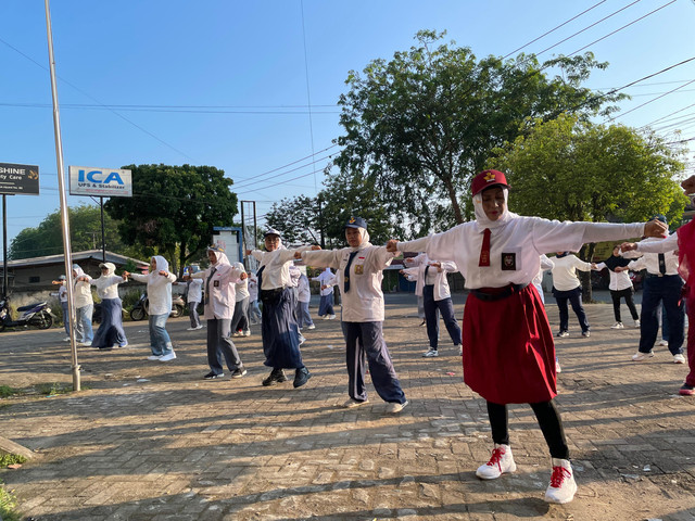 Sejumlah ibu-ibu dari POSMI senam dengan memakai seragam sekolah di Jalan Uray Bawadi, Pontianak. Foto: Rabiansyah/Hi!Pontianak