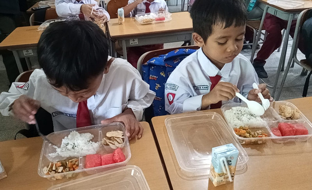 Siswa di Surabaya sedang menyantap MBG. Menurut pakar kesehatan keracunan MBG dikarenakan penanganan makanan yang kurang tepat, contohnya dalam aspek penyimpanan dan distribusi. Foto: Masruroh/Basra