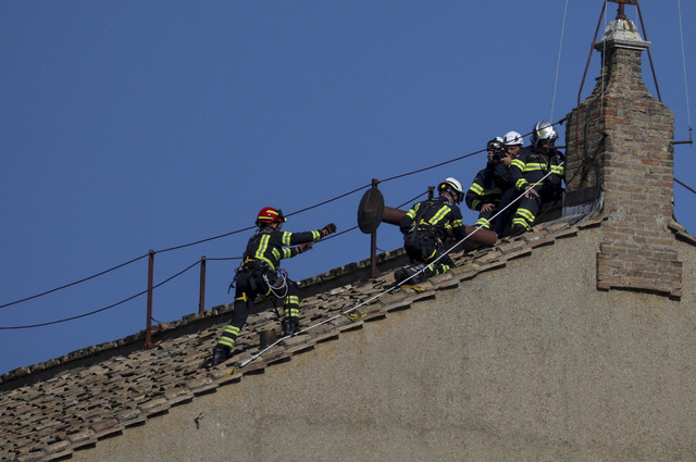 Petugas pemadam kebakaran bekerja di atap Kapel Sistina untuk memasang cerobong asap, menjelang konklaf, di Vatikan, Jumat (2/5/2025). Foto: Stoyan Nenov/REUTERS