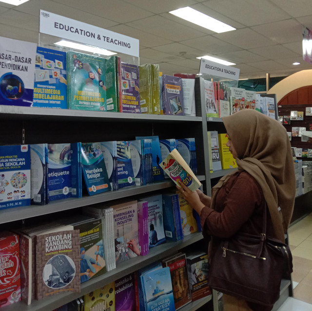 Foto ini diambil oleh Anita Dwiyanti, menangkap momen seseorang yang sedang membaca buku fisik di era digital. Sebuah refleksi tentang bagaimana literasi tetap relevan di tengah kemajuan teknologi.