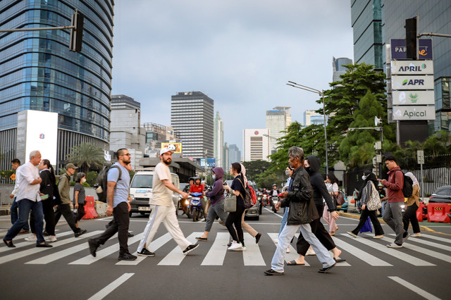 Pekerja melintasi pelican crossing saat jam pulang kerja di Kawasan Jalan Jendral Sudirman, Jakarta, Senin (5/5/2025). Foto: Jamal Ramadhan/kumparan