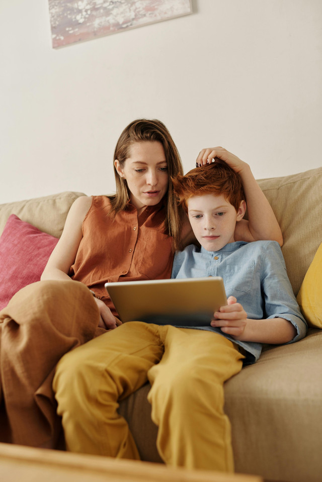 Ilustrasi ibu dan anak sedang menonton tablet bersama (Sumber : https://www.pexels.com/id-id/foto/foto-perempuan-dan-laki-laki-menonton-melalui-komputer-tablet-4145349/)