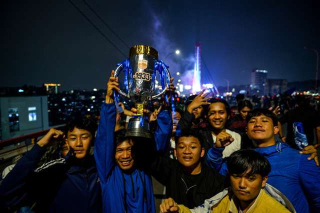 Bobotoh mengangkat replika piala di Jembatan Layang Mochtar Kusumaatmadja di Bandung, Jawa Barat, Senin (5/5/2025). Foto: Raisan Al Farisi/ANTARA FOTO