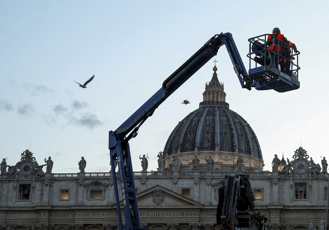 Pekerja dibantu alat berat bersiap menjelang konklaf pemilihan Paus di Gereja Basilika Santo Petrus, Vatikan, Senin (5/5/2025). Foto: Marko Djurica/Reuters