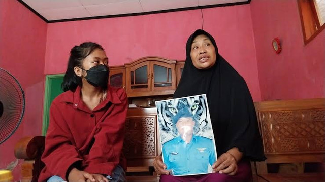 Keluarga dari Pekerja Migran Indonesia (PMI) asal Banyuwangi menunjukkan foto Rizal Sampurna yang tewas di Kamboja, Rabu (7/5). Foto: Dok. kumparan