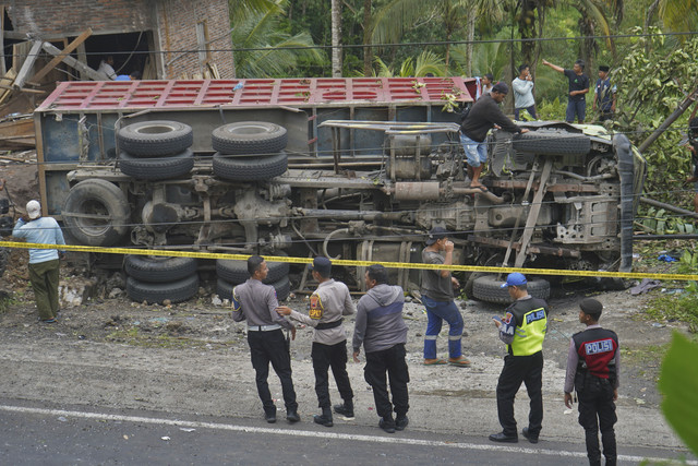 Polisi berjaga di lokasi kecelakaan truk tronton bermuatan pasir tabrak mobil angkutan umum di jalan turunan Magelang-Purworejo Desa Kalijambe, Bener, Purworejo, Jawa Tengah, Rabu (7/5/2025). Foto: Anis Efizudin/ANTARA FOTO