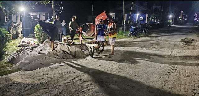 Warga Desa Antibar gotong royong perbaiki jalan rusak pada malam hari. Foto: M. Zain/Hi!Pontianak