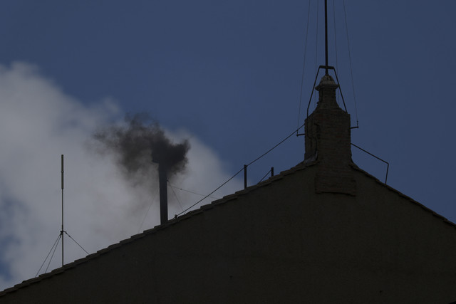 Asap hitam mengepul dari cerobong asap menandakan belum ada keputusan yang diambil untuk memilih paus baru di Kapel Sistina, Vatikan, Kamis (8/5/2025). Foto: Hannah McKay/Reuters