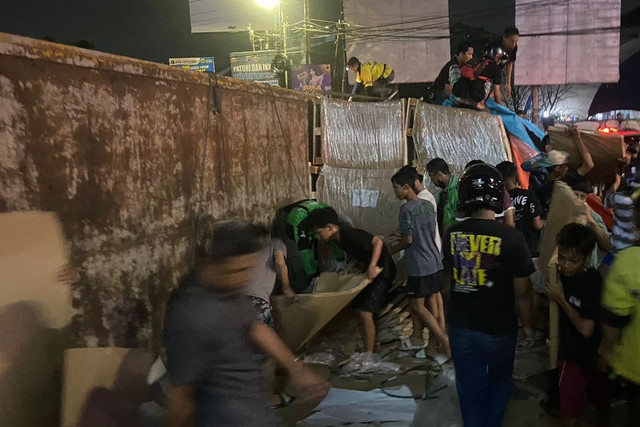 Petugas dan warga bahu membahu mengevakuasi truk kertas yang terguling di Jalan dr Wahidin Semarang. Foto: Dok. Istimewa