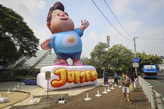 Seorang bapak menggendong anaknya untuk menyaksikan balon raksasa karakter Don dalam film Jumbo setinggi 10 meter di Taman Menteng, Jakarta, Sabtu (10/5/2025). Foto: Iqbal Firdaus/kumparan